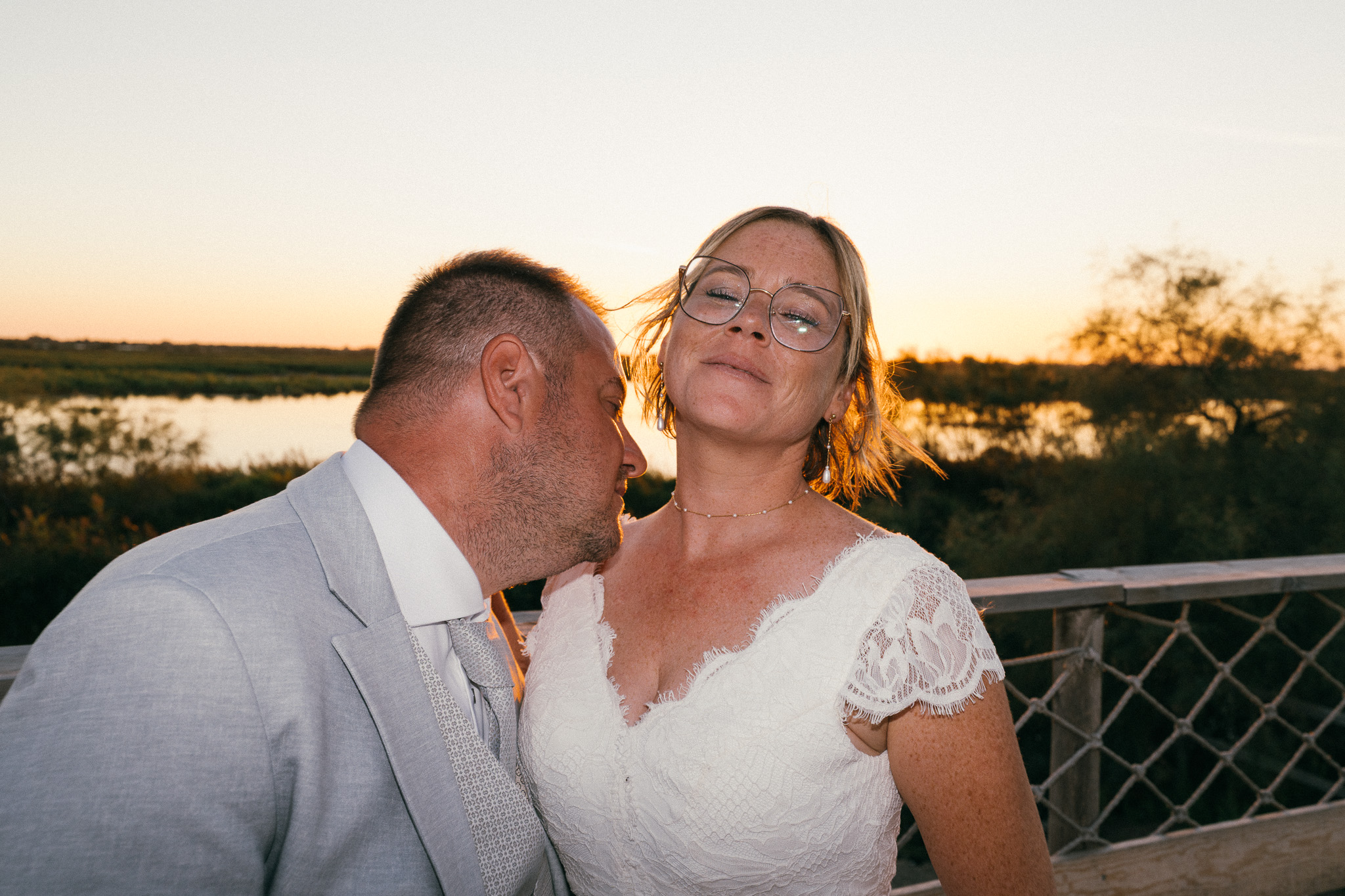 A kiss on the shoulder and a smile beside the water at the end of the day.