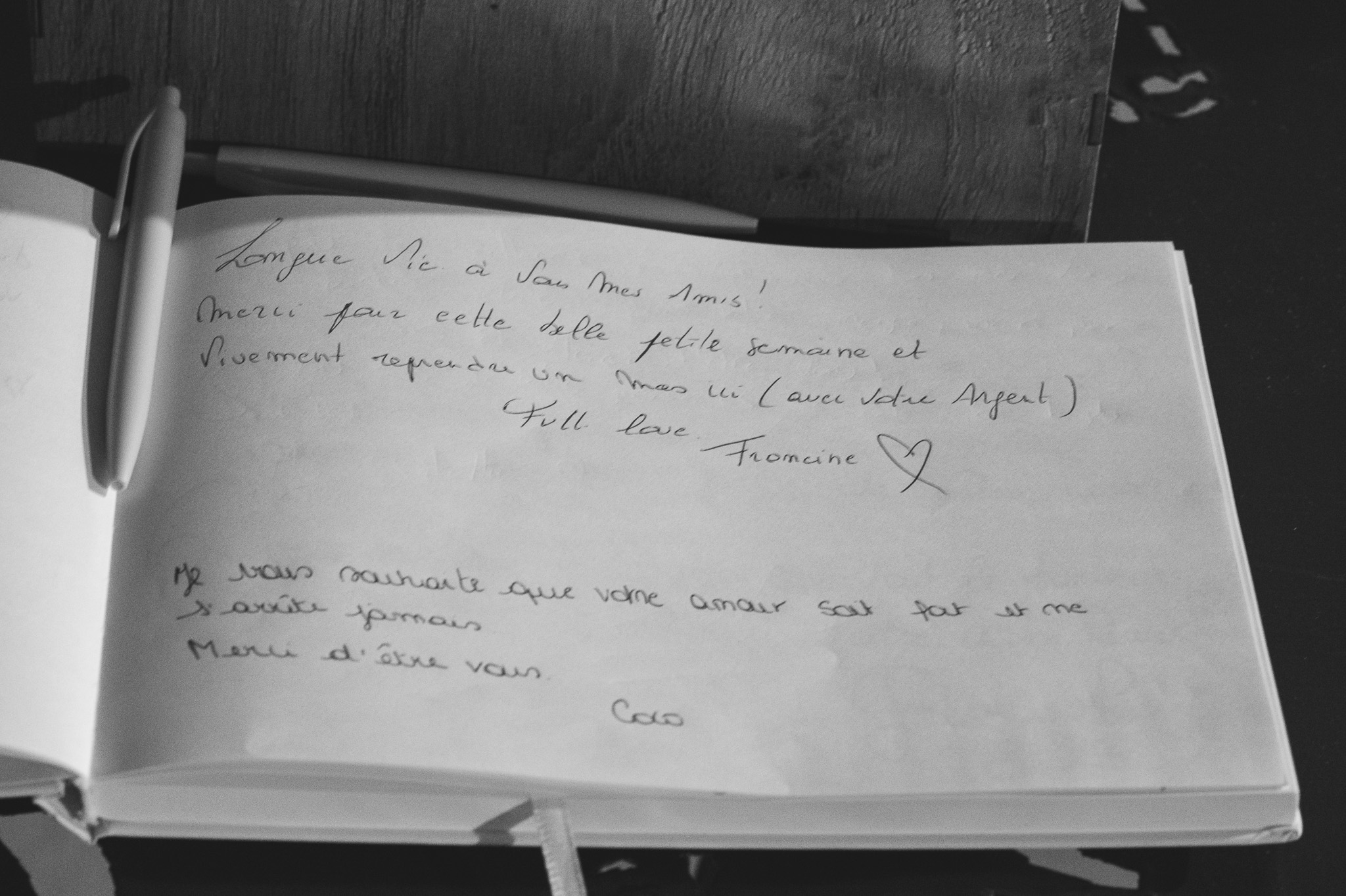 The guest book open at handwritten messages, photographed in black and white.