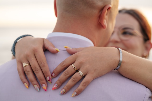 The bride’s hands resting on her partner’s shoulders.