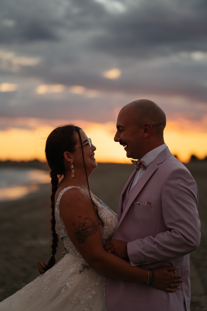 The couple smiling at each other in the last light of the evening.